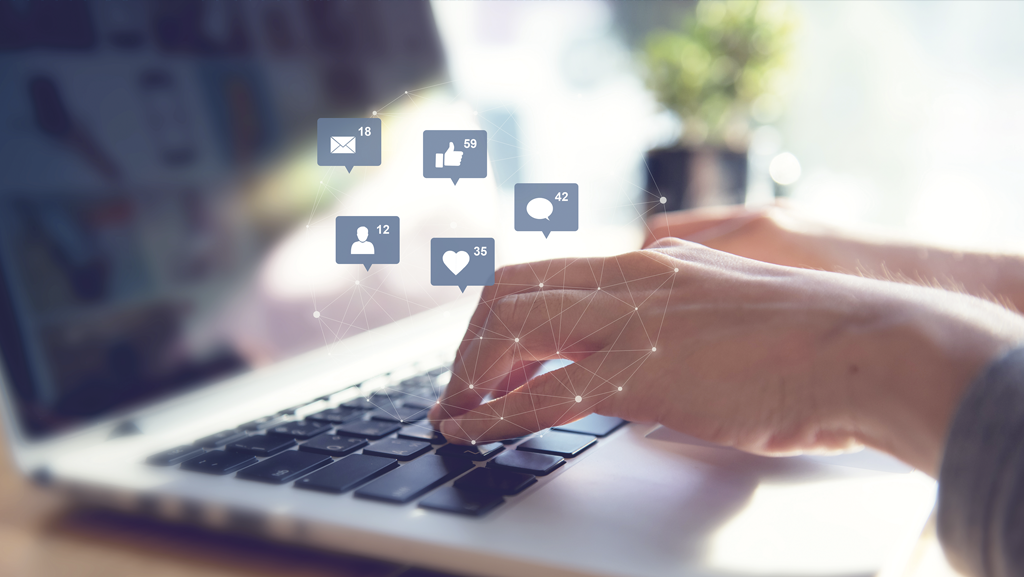 Person am Laptop nutzt Social Media