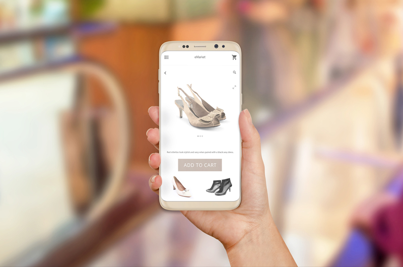 Person schaut sich auf dem Smartphone Schuhe an
