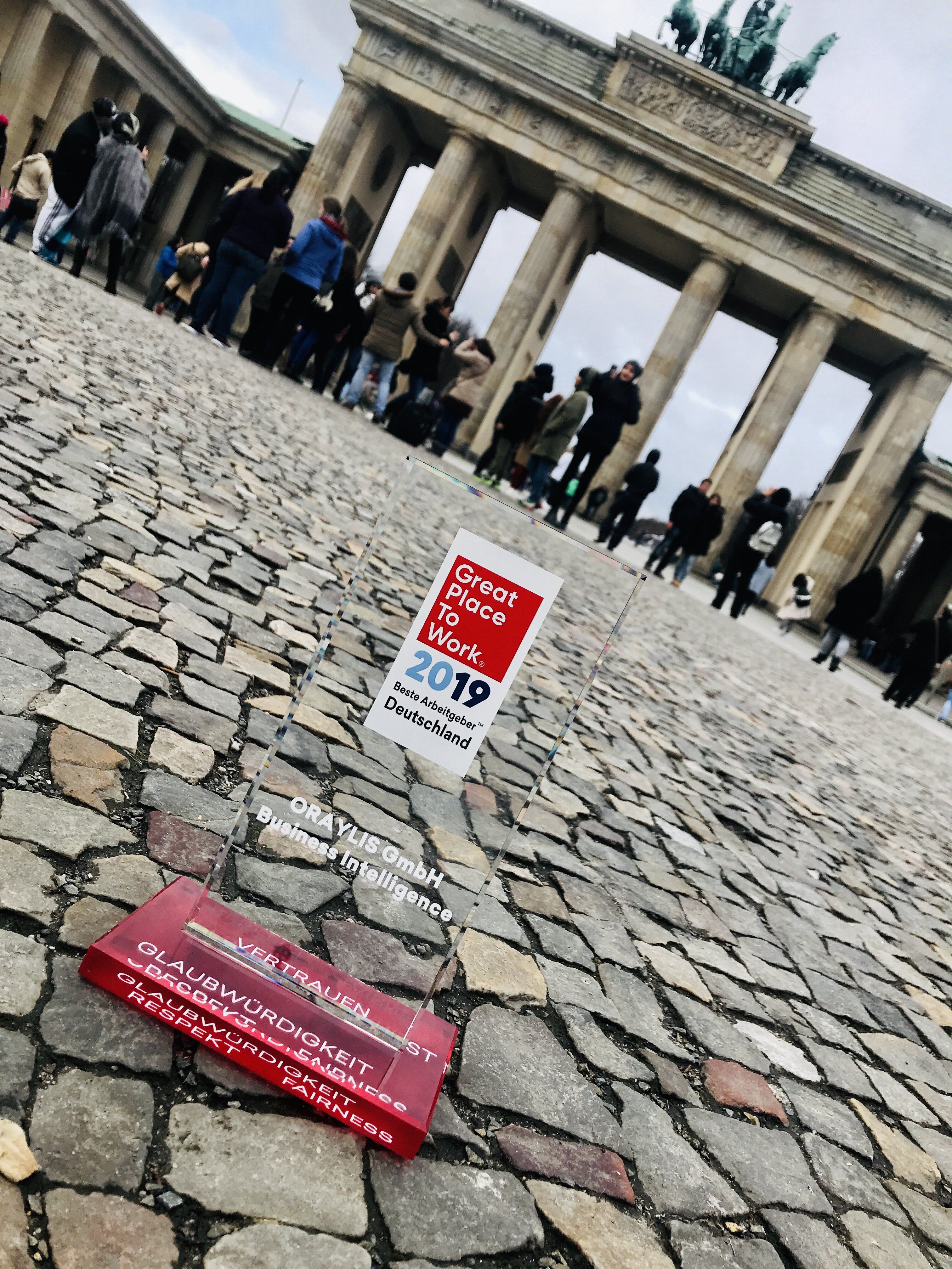 Great Place to Work Award für Oraylis vor Brandenburger Tor