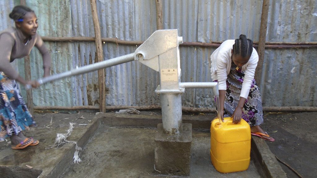 Äthiopische Mädchen pumpen Wasser aus einem Brunnen, der mit Spendengeldern der Neven Subotoc Stiftung gebaut wurde
