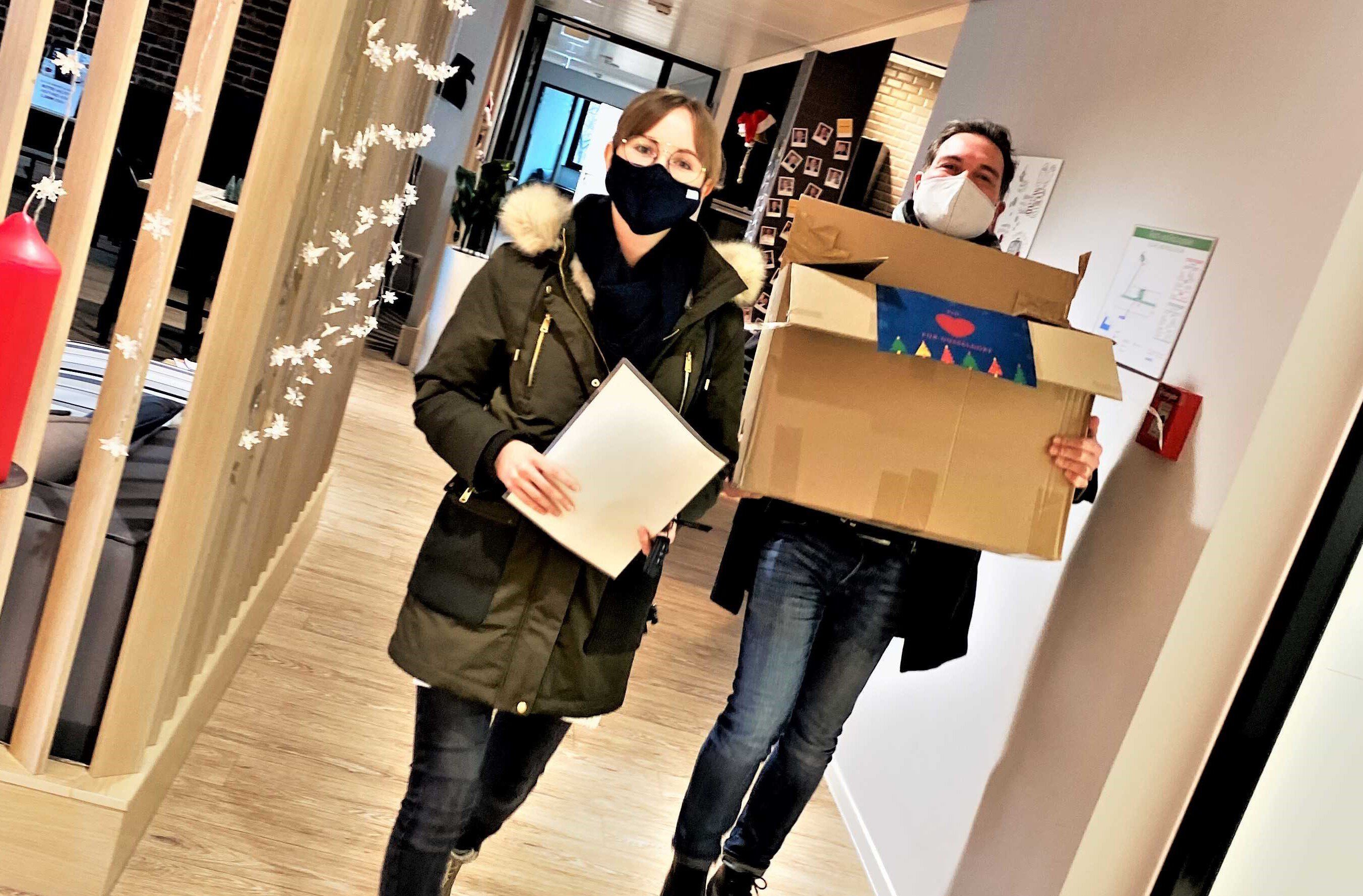 ORAYLIS Mitarbeiter tragen Weihnachtsspenden aus dem Office
