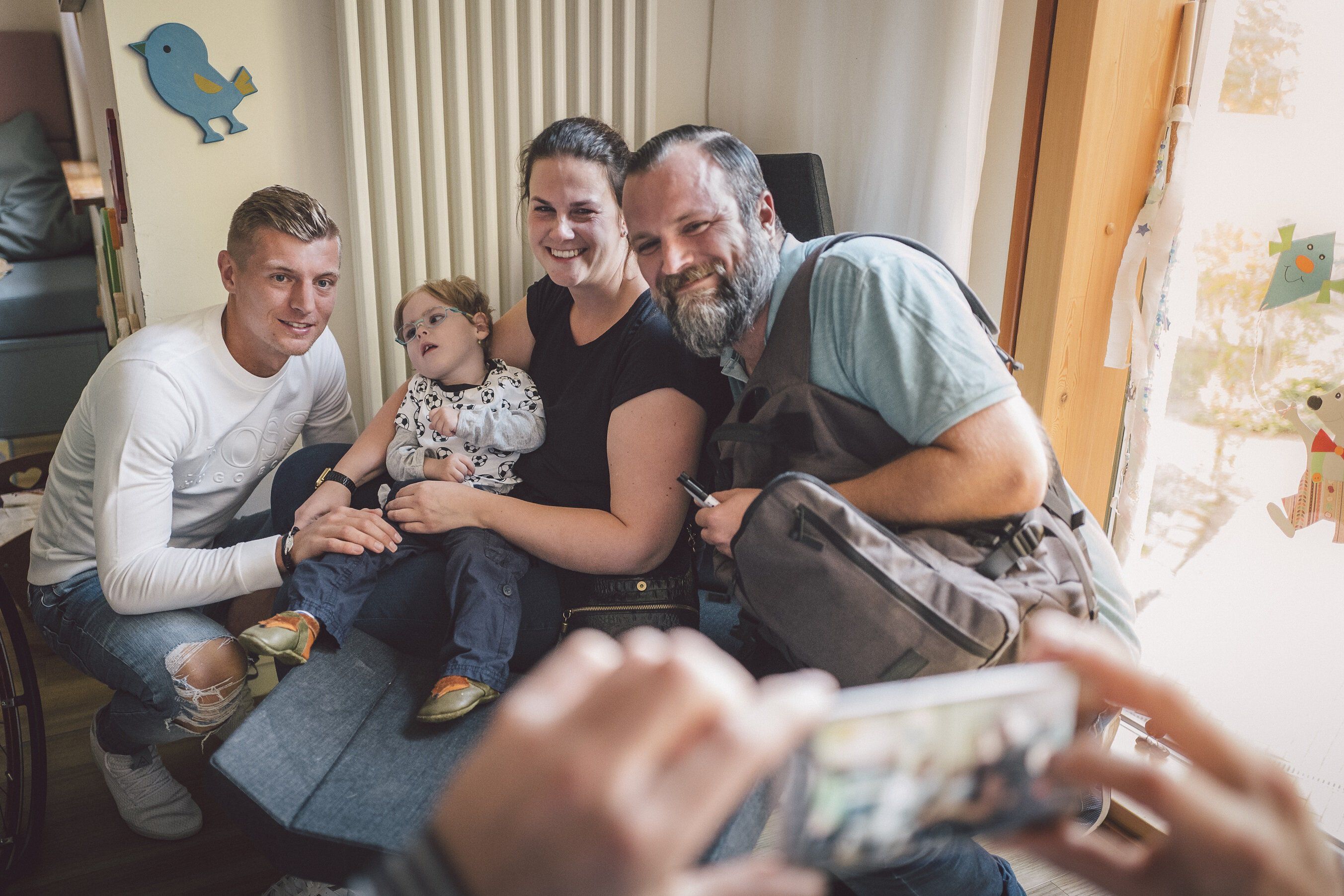 Toni Kroos mit einer Familie als Spendenempfänger
