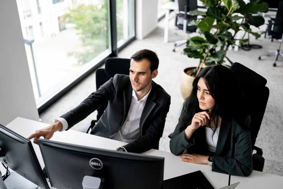 Large Language Models - Frau und Mann für Computer-Bildschirmen